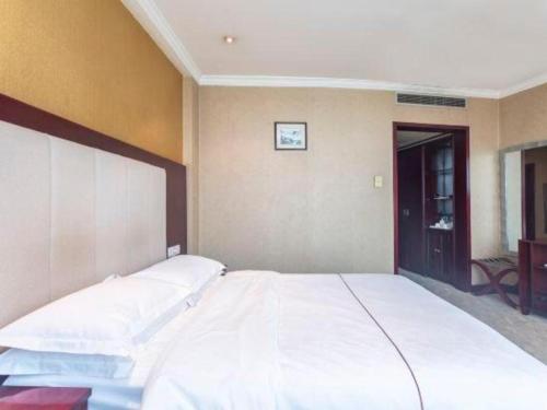 a large white bed in a room at Jincheng Pacific Hotel in Jincheng