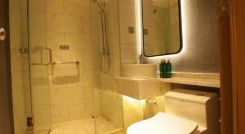 a bathroom with a shower and a toilet and a sink at Magnotel Business Jining Huancheng North Road in Jining