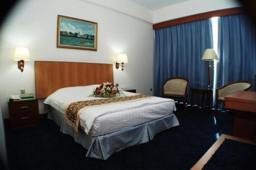 a hotel room with a large bed with flowers on it at Kiulap Plaza Hotel in Bandar Seri Begawan