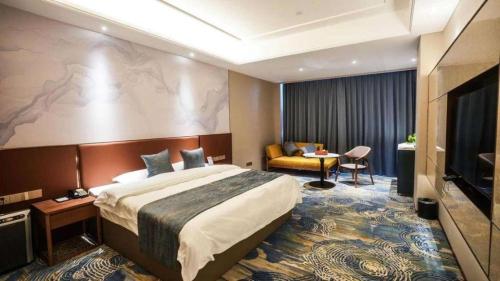 une chambre d'hôtel avec un grand lit et un canapé dans l'établissement Qingdao Huaxi Hotel Laixi, à Laixi