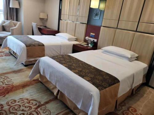 a hotel room with two beds and a chair at Chengdu Antai Century Hotel in Chengdu