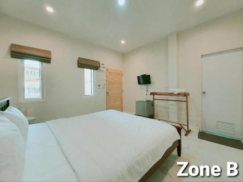 a bedroom with a large white bed and a television at Ban Glai Kong in Chiang Khan
