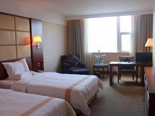 a hotel room with two beds and a desk at Fuzhou Fuqing Ruixin Hotel in Fuzhou