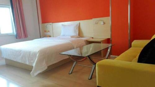 a bedroom with a bed and a table and a couch at 7 Days Inn Beijing Shunyi Development Area Mordern Motor City in Beijing