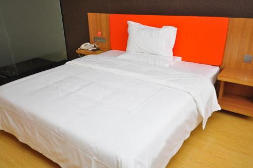 a large white bed in a room with an orange headboard at 7 Days Premium Dezhou Qingyun Nanhuan Building Materials Market in Dezhou