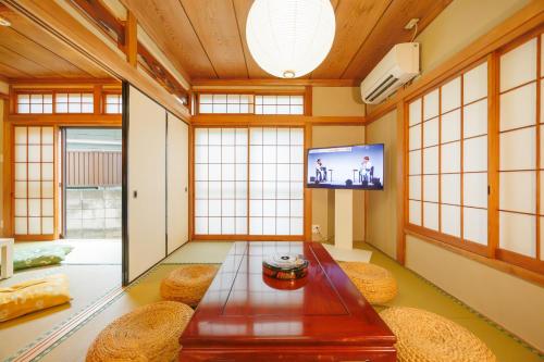 a living room with a table and a tv at Sankuya House in Kawaguchi