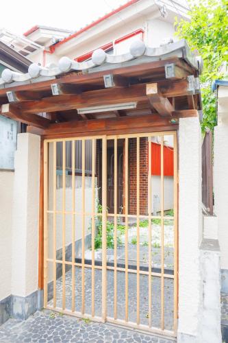 a gate to a house under a roof at Sankuya House in Kawaguchi