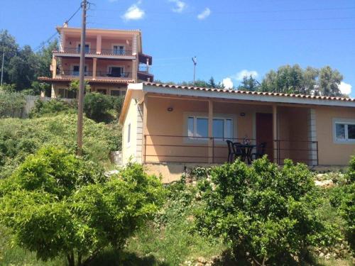 ein Haus auf einem Hügel in der Unterkunft Takis & Eirini Family Apartments in Perama