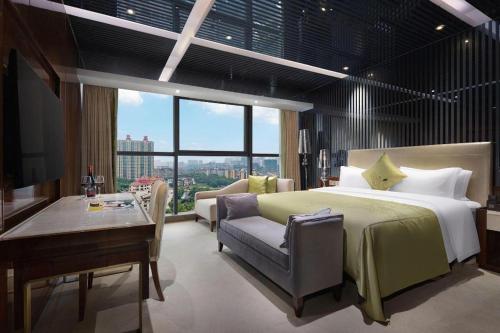 a bedroom with a bed and a couch and a table at Yongzhou Chuang Fa Cheng XiaoXiangYi Hotel in Guzhuting