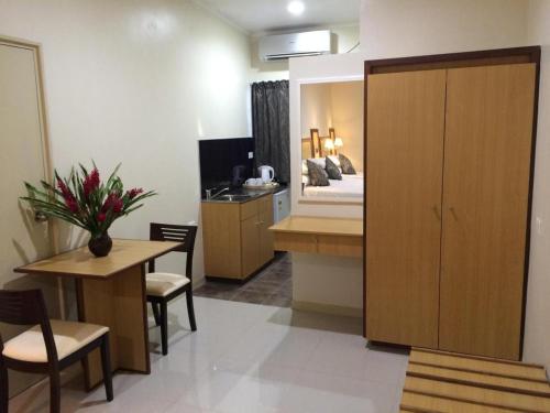 ein Zimmer mit einem Schlafzimmer mit einem Bett und einem Tisch in der Unterkunft Victoria Palms Hotel in The Domain