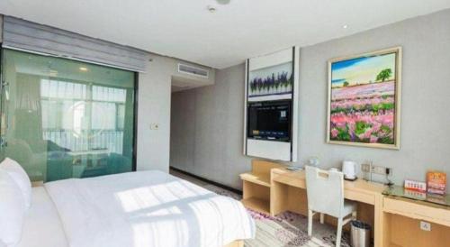 a bedroom with a bed and a desk and a television at Lavande Hotel Yichang Railway East Station Branch in Yichang