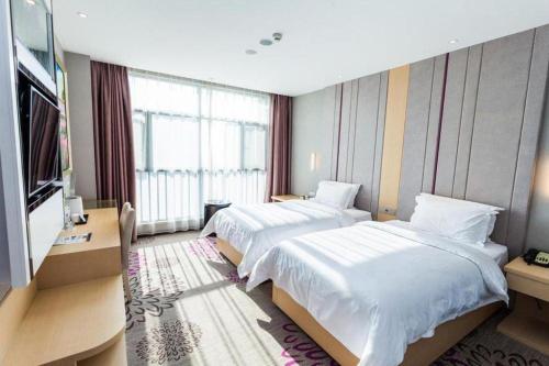 a hotel room with two beds and a large window at Lavande Hotel Yichang Railway East Station Branch in Yichang