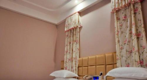 a hotel room with two beds and curtains at TO915101 STILL LOVE THEME HOTEL in Chengdu