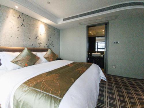 a bedroom with a large bed in a room at Yongzhou Chuang Fa Cheng XiaoXiangYi Hotel in Guzhuting