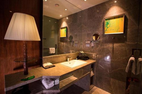 a bathroom with a sink and a lamp on a counter at Yongzhou Chuang Fa Cheng XiaoXiangYi Hotel in Guzhuting