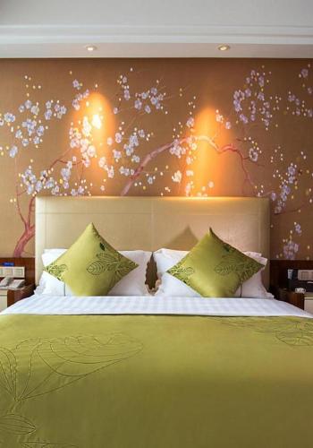a bedroom with a large bed with yellow pillows at Yongzhou Chuang Fa Cheng XiaoXiangYi Hotel in Guzhuting