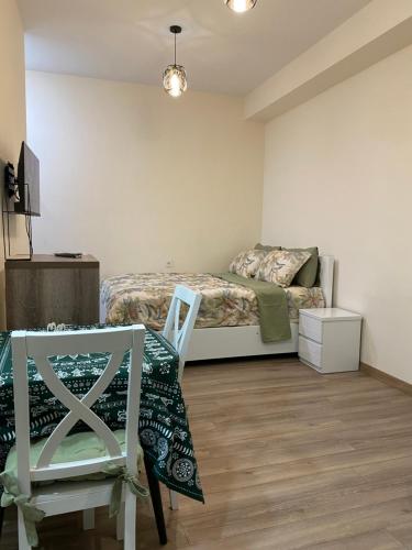 a bedroom with a bed and a chair and a table at Avlabari Inn - The coziest place in Tbilisi City