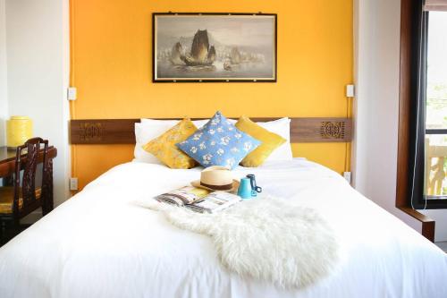 a bedroom with a white bed with yellow walls at Chinatown Night Market - Family Suite 2 BRs in Chiang Mai