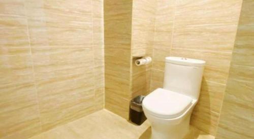 a bathroom with a white toilet in a room at Metropolo Hotel Qingdao Wusi Square Xiaomaidao in Qingdao