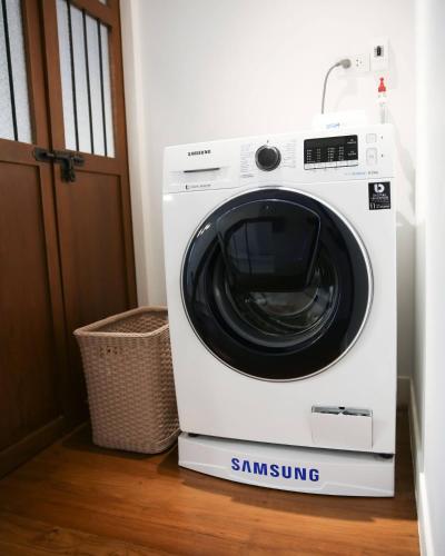 a white washing machine sitting on a floor next to a door at Chinatown Night Market - Family Suite 2 BRs in Chiang Mai