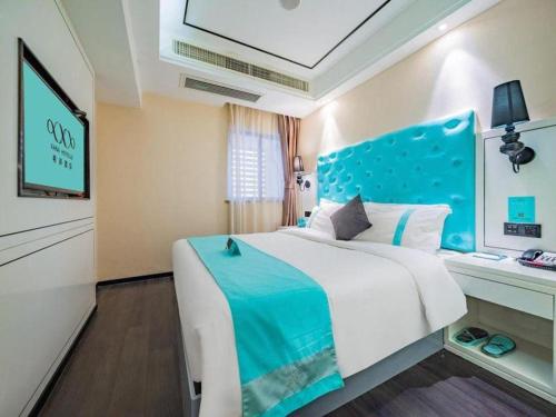 a bedroom with a large bed with a blue headboard at Xana Hotelle Xi'an 2nd Fengcheng Road Municipal Library Metro Station in Xi'an