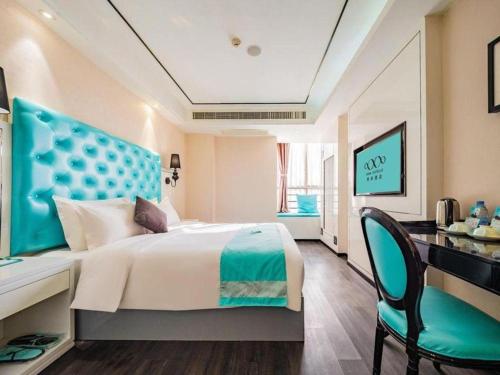 a bedroom with a bed and a desk and a chair at Xana Hotelle Xi'an 2nd Fengcheng Road Municipal Library Metro Station in Xi'an