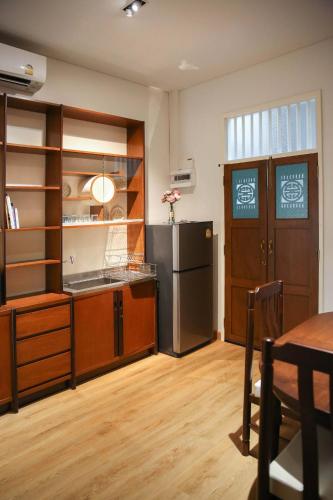 a kitchen with a refrigerator and a table in a room at Chinatown Night Market - Family Suite 2 BRs in Chiang Mai
