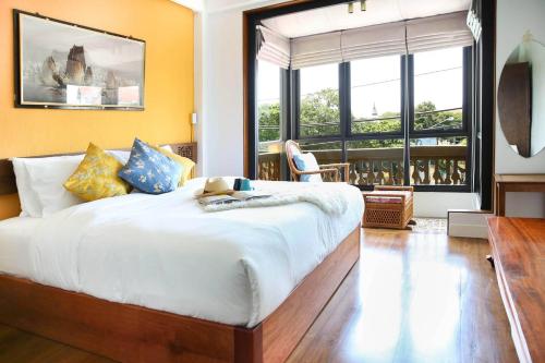 a bedroom with a large bed and a large window at Chinatown Night Market - Family Suite 2 BRs in Chiang Mai