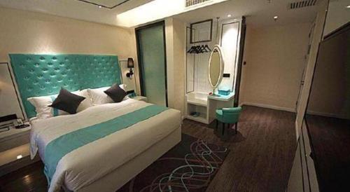 a bedroom with a large bed and a mirror at Xana Lite Korla Shihua Avenue Longquehe in Korla
