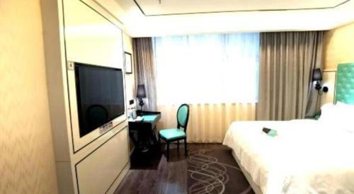 a hotel room with a bed and a television at Xana Lite Korla Shihua Avenue Longquehe in Korla