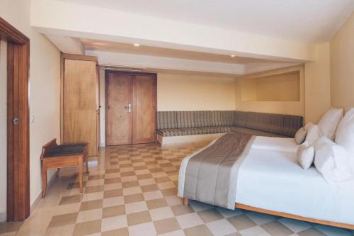a bedroom with a large bed and a desk at Iberostar Selection Kantaoui Bay in Port El Kantaoui
