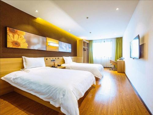 a hotel room with two beds and a window at IU Hotel Chongqing Jiangbei International Airport in Chongqing