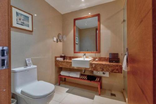 a bathroom with a toilet and a sink and a mirror at Yitel Xi'an Hi-tech Zone Wanda Plaza in Xi'an