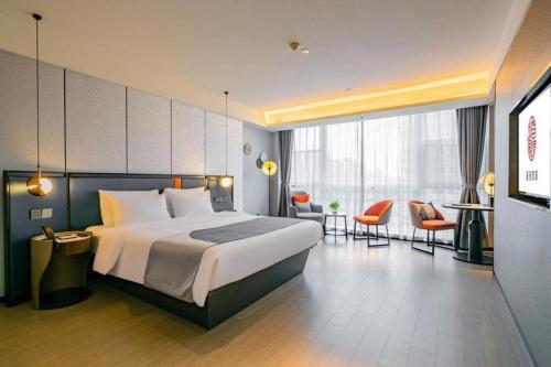 a hotel room with a bed and a desk and chairs at Yitel Xi'an Hi-tech Zone Wanda Plaza in Xi'an