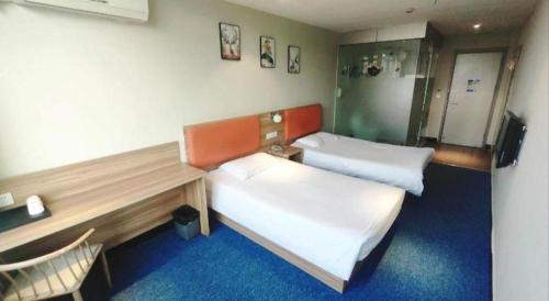 a room with two beds and a chair in it at Shanghai Jiejia hotel in Shanghai