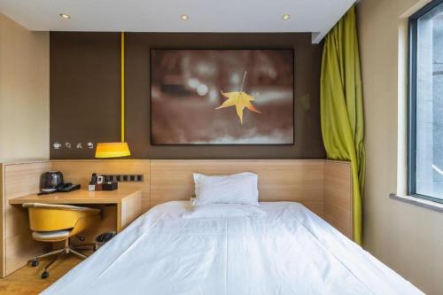 a bedroom with a bed and a desk at IU Hotel Kunming Jinma Bijifang Joy City in Kunming