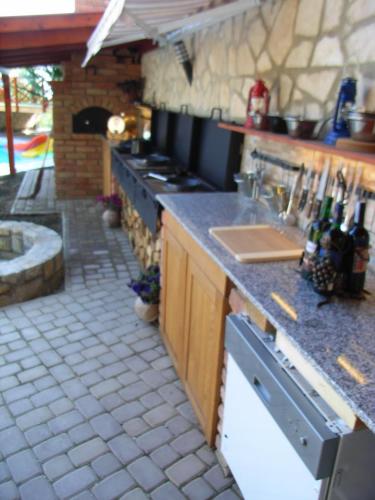 a kitchen with a counter with a stove top oven at HolidaySport Haus in Balatongyörök