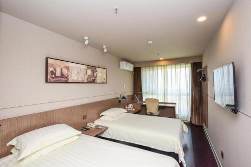 a hospital room with two beds and a television at Jinjiang Inn Style Shijiazhuang Zhongshan Xi Road Yuxi Park in Shijiazhuang