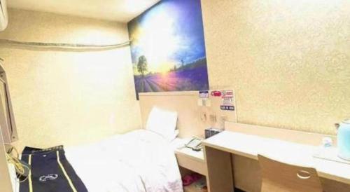 a hotel room with a bed and a desk with a phone at PAI Hotels·Urumqi South Gate Xinhua Bookstore in Ürümqi