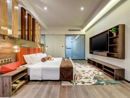 a hotel room with a bed and a flat screen tv at James Joyce Coffetel·Anyang Text Museum in Anyang