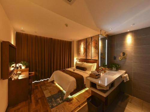 a bedroom with a bed and a bathroom with a sink at James Joyce Coffetel·Beijing Yizhuang Development Zone Dazu Square Tongji Road in Beijing