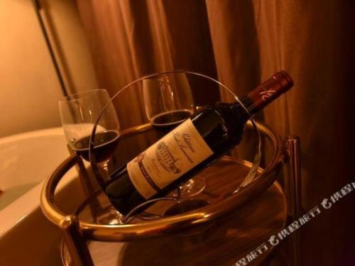a bottle of wine in a metal holder with wine glasses at James Joyce Coffetel·Beijing Yizhuang Development Zone Dazu Square Tongji Road in Beijing