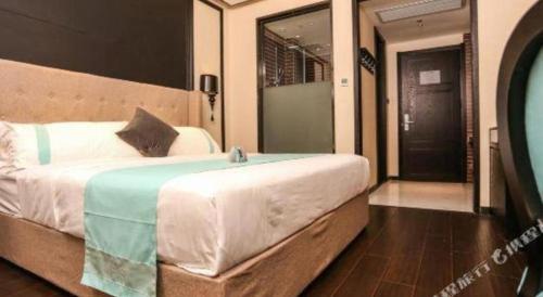 a bedroom with a large bed and a mirror at Xana Hotelle·Ji'nan Hi-tech Zone Century Avenue Tangye in Jinan