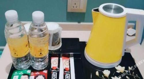 a table with two drinks and two rubber boots at Magnotel Hotel Suzhou Guanqian Street Pingjiang Road in Suzhou