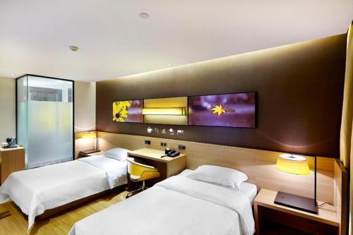 Giường trong phòng chung tại IU Hotel·Tianjin Binhai New District Yanghuo Market