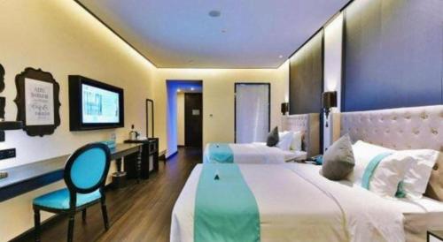 a bedroom with two beds with a desk and a chair at Xana Hotelle Chengdou Xindu Sanhechang Metro Station in Chengdu