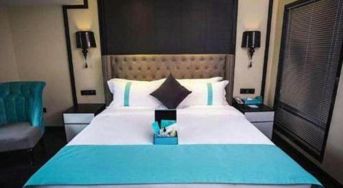 a bedroom with a large blue and white bed at Xana Hotelle Chengdou Xindu Sanhechang Metro Station in Chengdu
