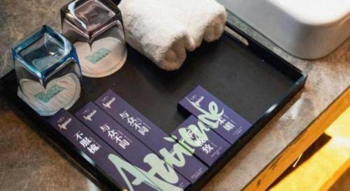 a box with two pairs of shoes on a table at Xana Hotelle Chengdou Xindu Sanhechang Metro Station in Chengdu