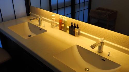 a bathroom with two sinks and a large mirror at Shin Kadoya in Atami