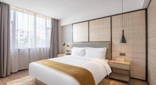 a bedroom with a large bed and a large window at Echarm Hotel Zibo Gaoqing Zhongcheng Inernational in Zibo